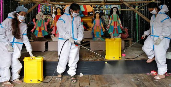 Personal desinfecta la zona donde se celebrará el festival Burga Puja (Reuters)